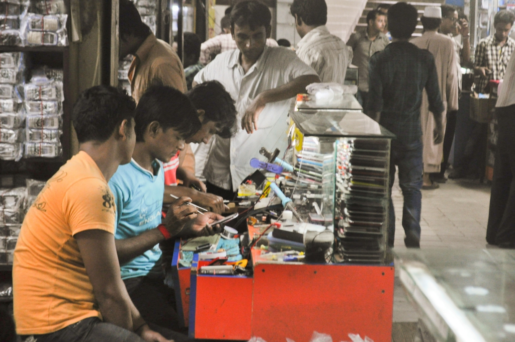 Phone repairers in a Bangladeshi workshop before the COVID pandemic