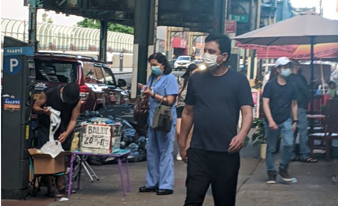 Several people walking down busy street