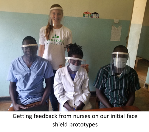 Paige Balcom behind three people in medical attire wearing face shields