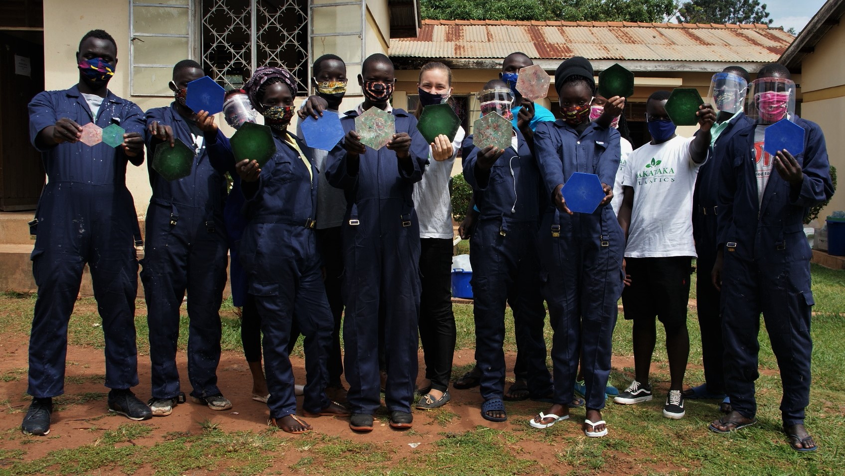 A group of Taka Taka workers show off their recycled plastic construction material