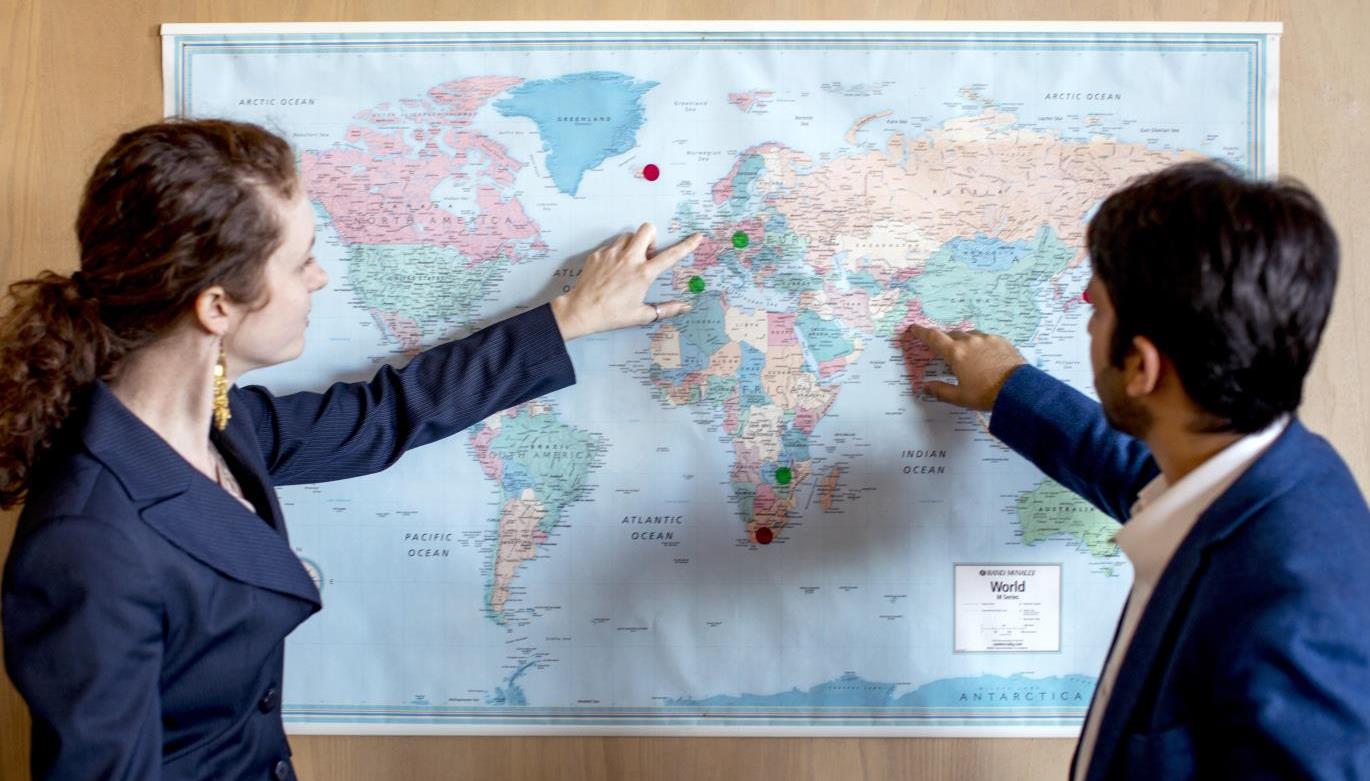 Two students looking at a map of the World