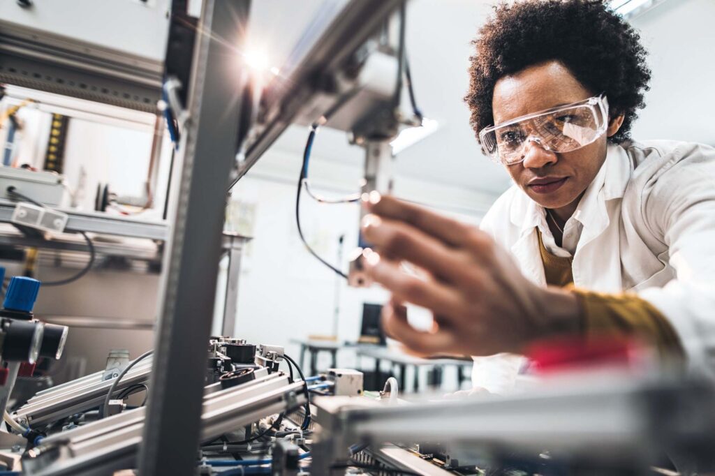 female engineer working on industrial machine in a laboratory.