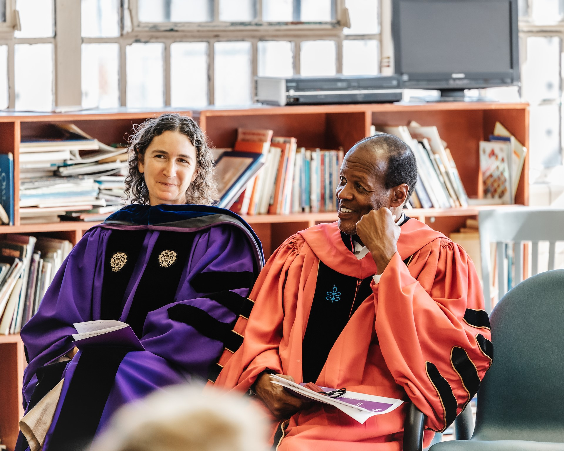 IIE Centennial Fellow Mneesha Gellman and colleague sit in their academic robes at the EPI graduation
