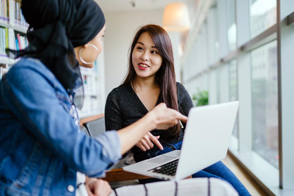 A Chinese Asian woman has a business meeting with a Malay Muslim woman.