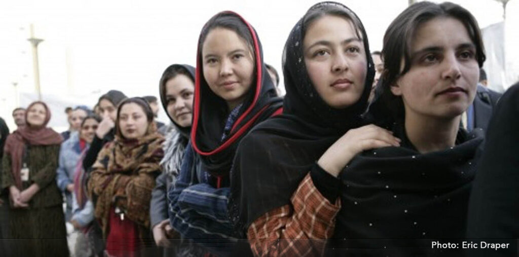 Photo by Eric Draper of Afghan women standing together in a line looking hopeful.