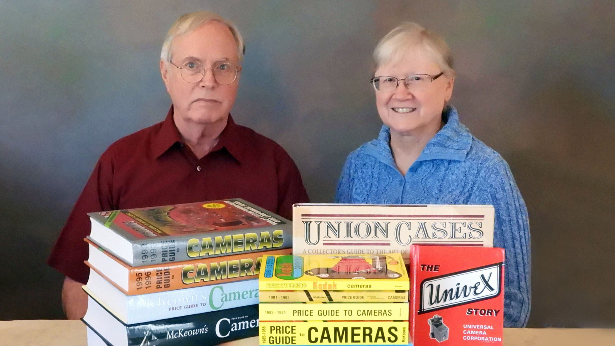 Jim and Joan McKeown pose with multiple books they've authored.