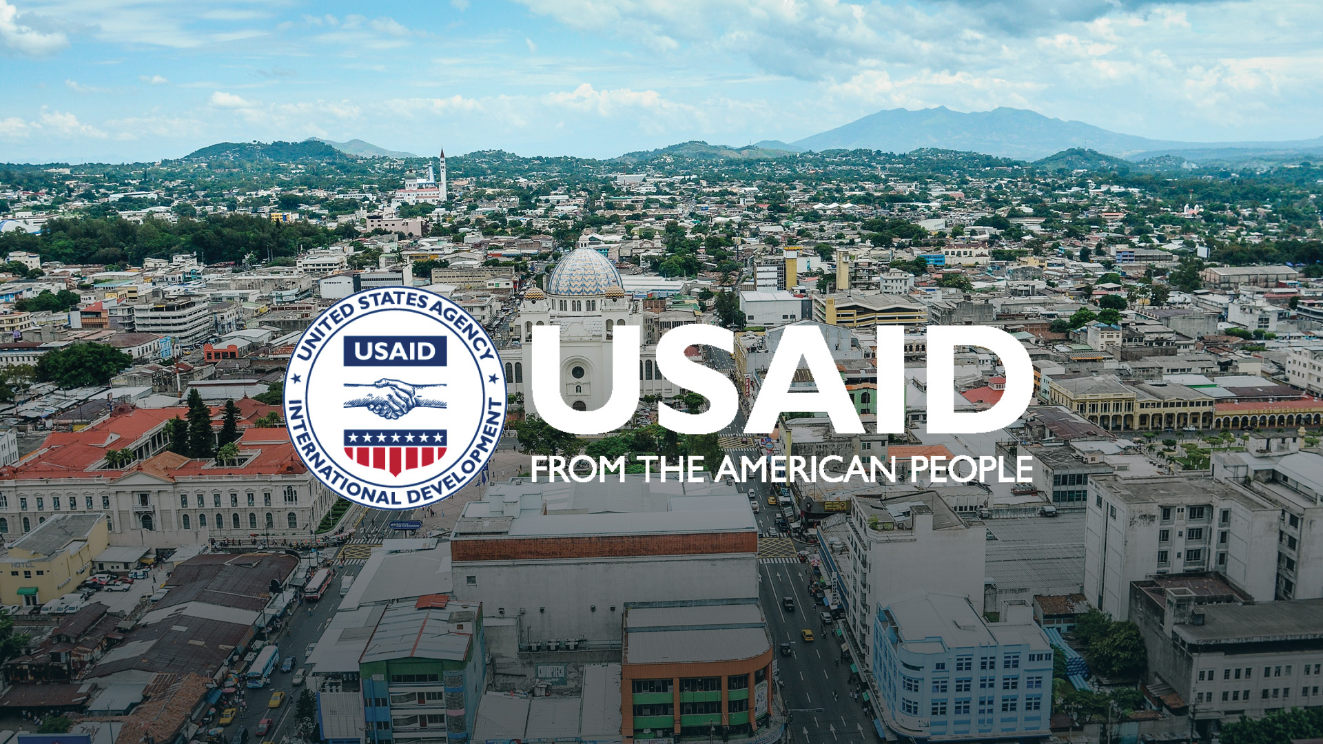 An aerial view of the city of San Salvador with USAID's logo laid over the top.