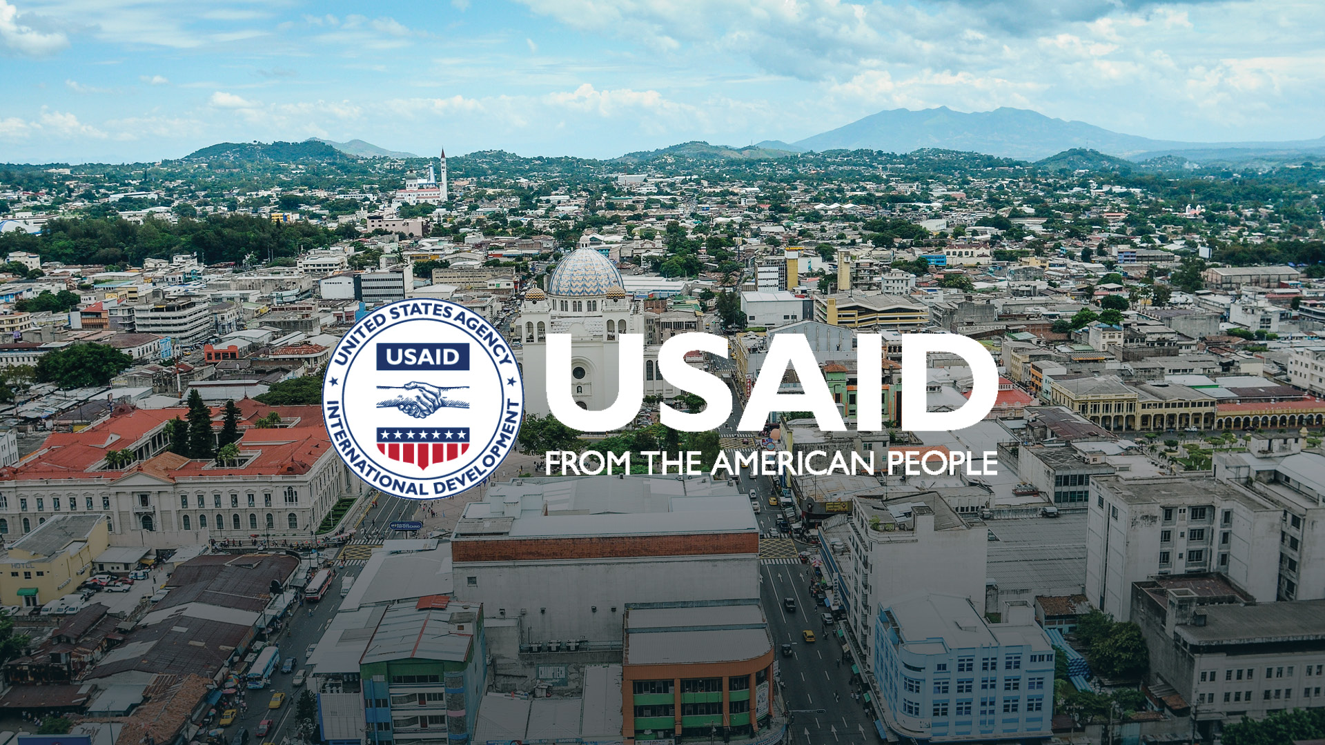 An aerial view of the city of San Salvador with USAID's logo laid over the top.